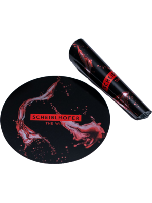 A round coaster and a wine bottle opener, both with red Scheiblhofer The Wine branding and red splashes.